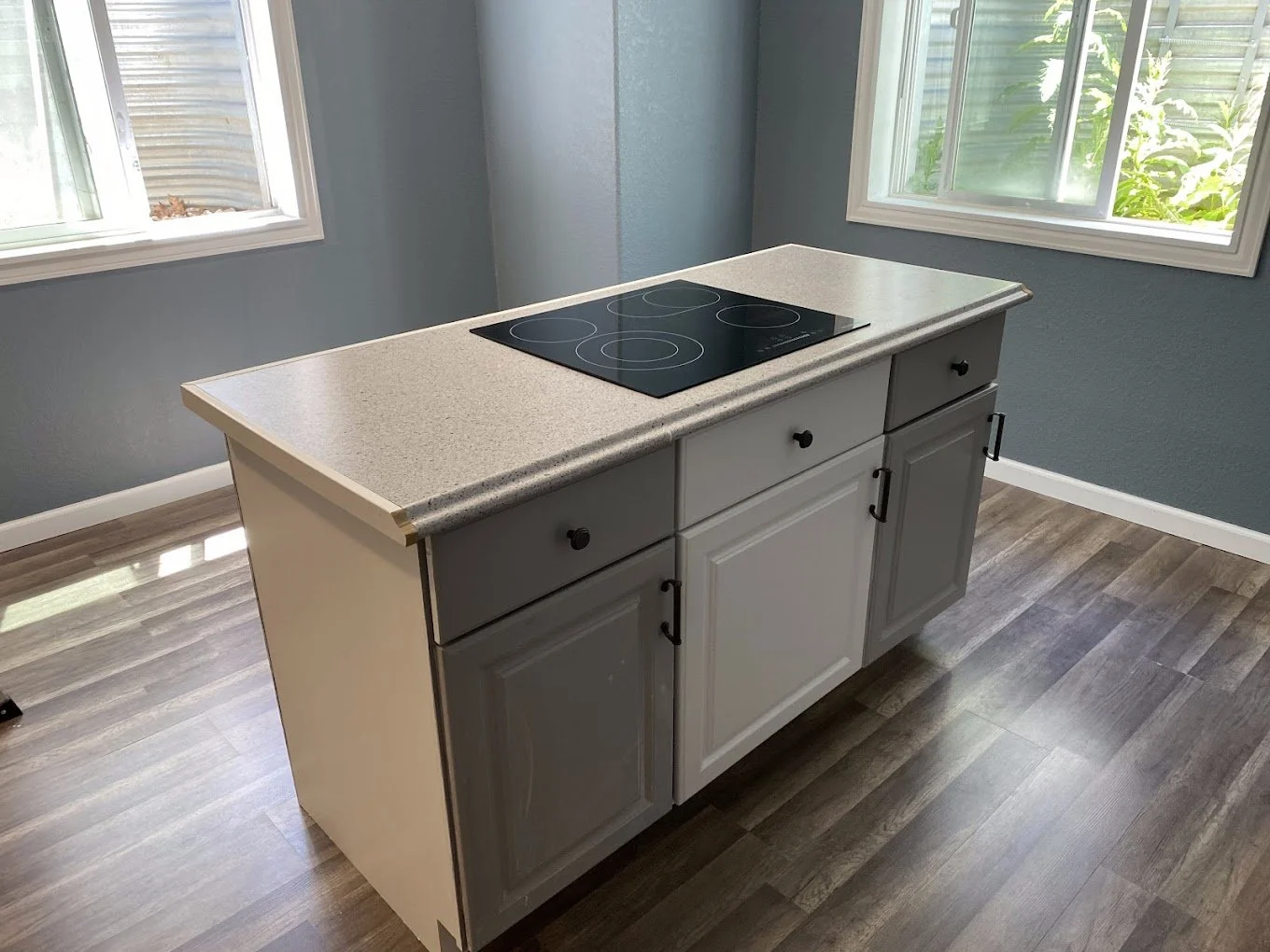 Remodeled kitchen island with a quartz countertop and built-in cooktop