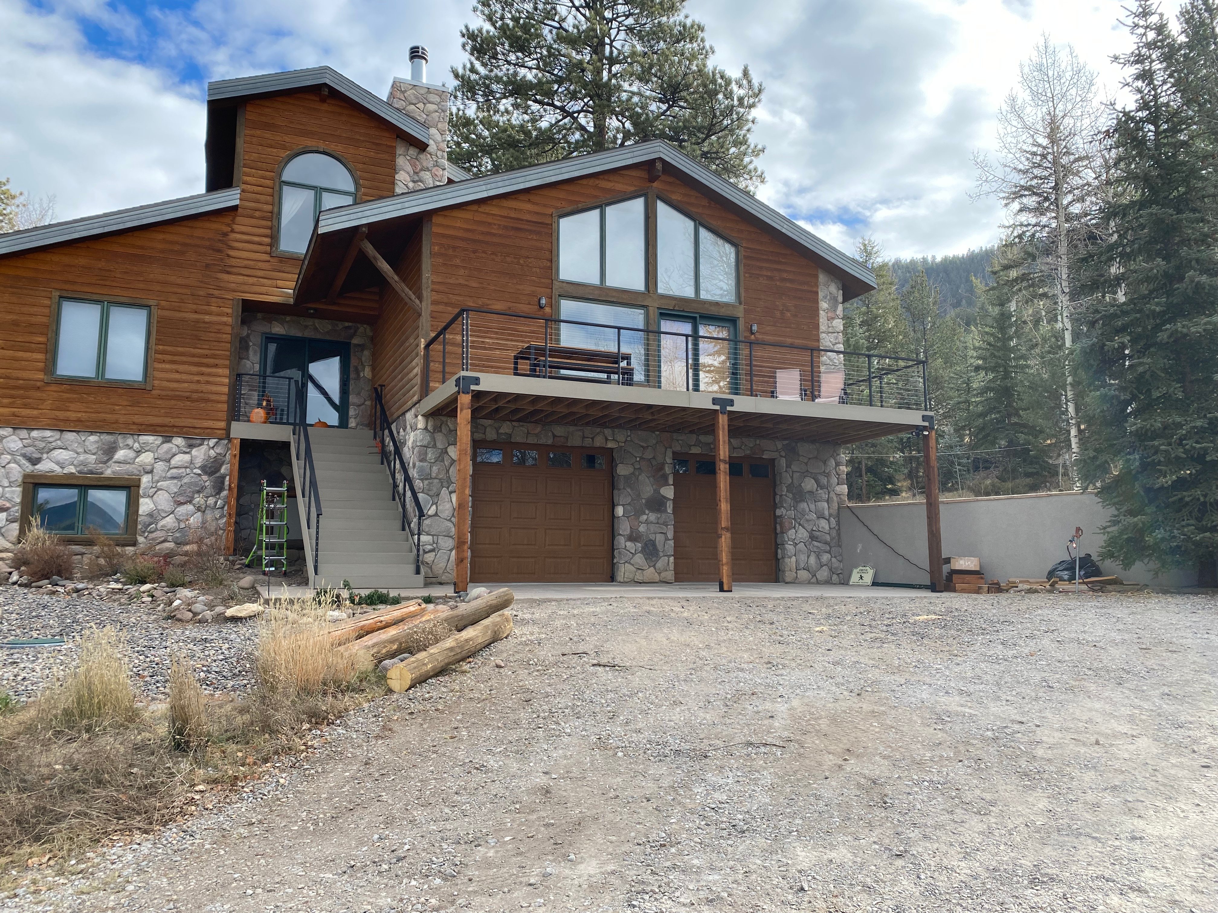 Log home in the Colorado mountains with a rebuilt composite deck and black steel railing
