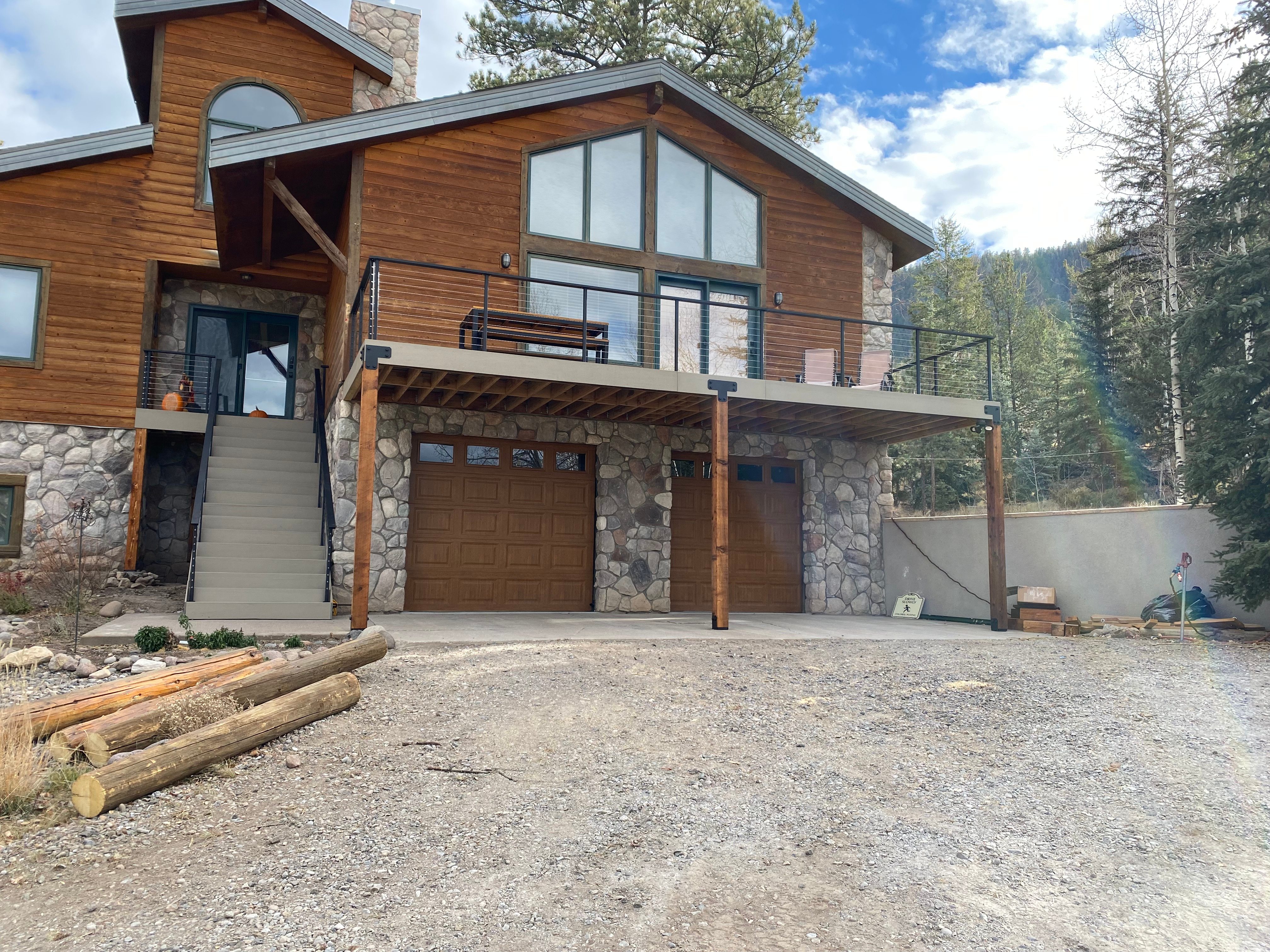 Upper deck over the garage with stone base and stair run