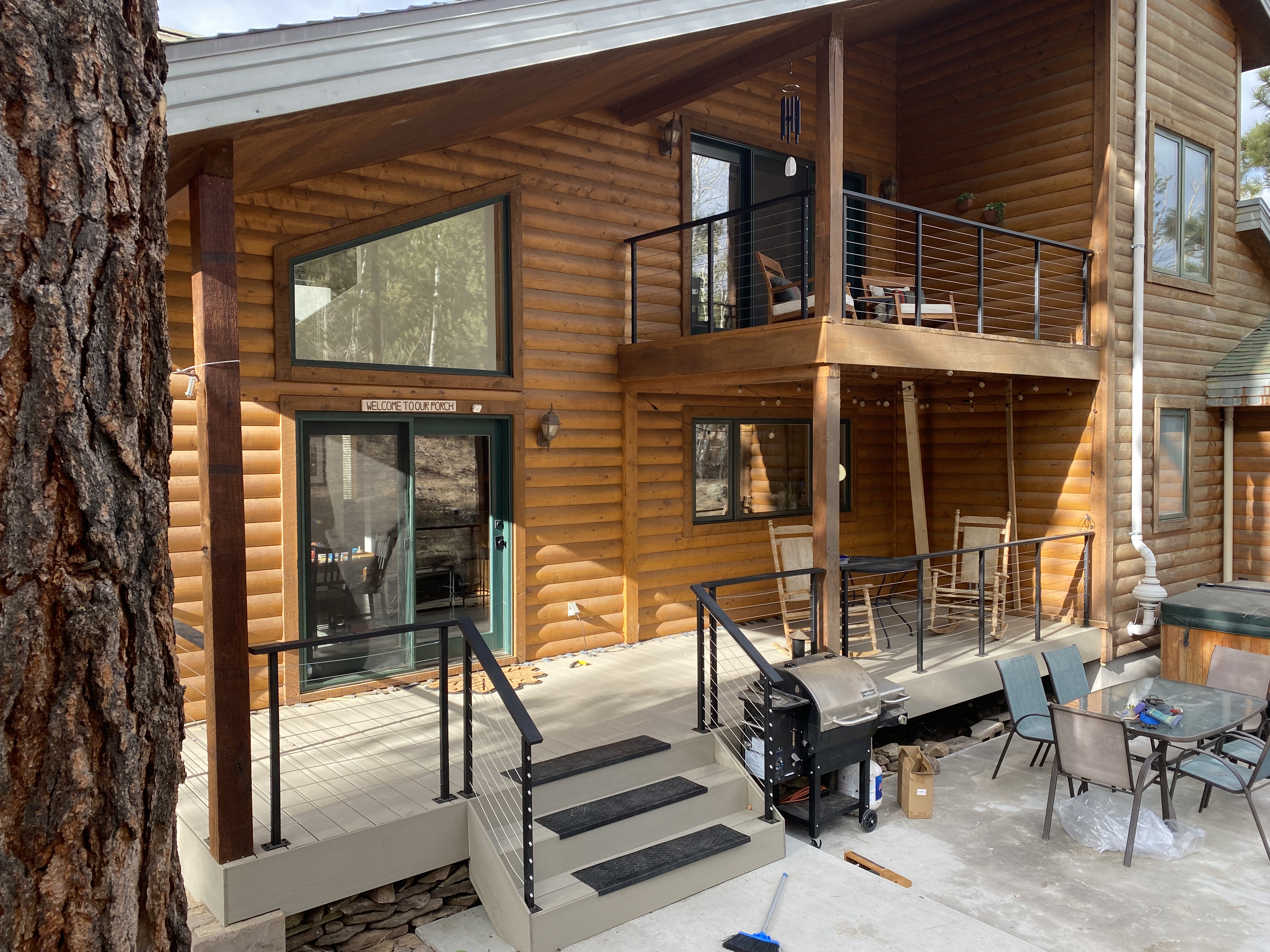 Covered lower deck with rocking chairs and horizontal steel railing