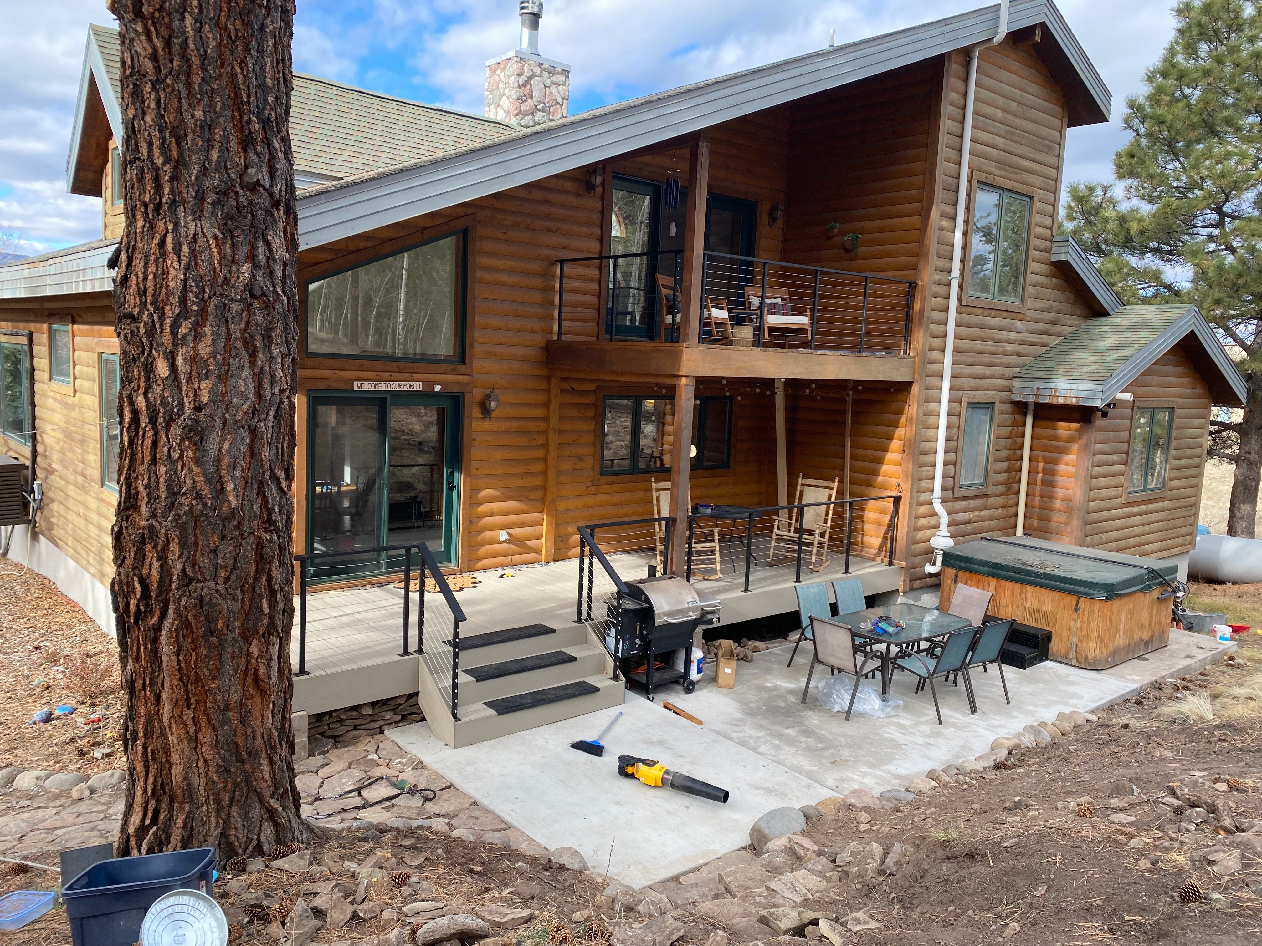 Wide view of the deck, patio and hot tub area at the back of the home